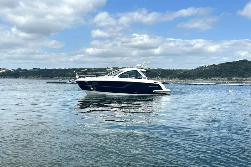Slide: The Image of 2017 Monterey 360 Sport Coupe yacht on a serene lake under a partly cloudy sky. - 12