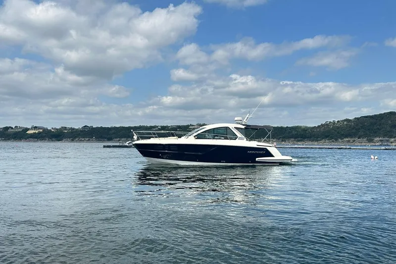 Slide: The Image of 2017 Monterey 360 Sport Coupe yacht on calm water under a partly cloudy sky. - 13