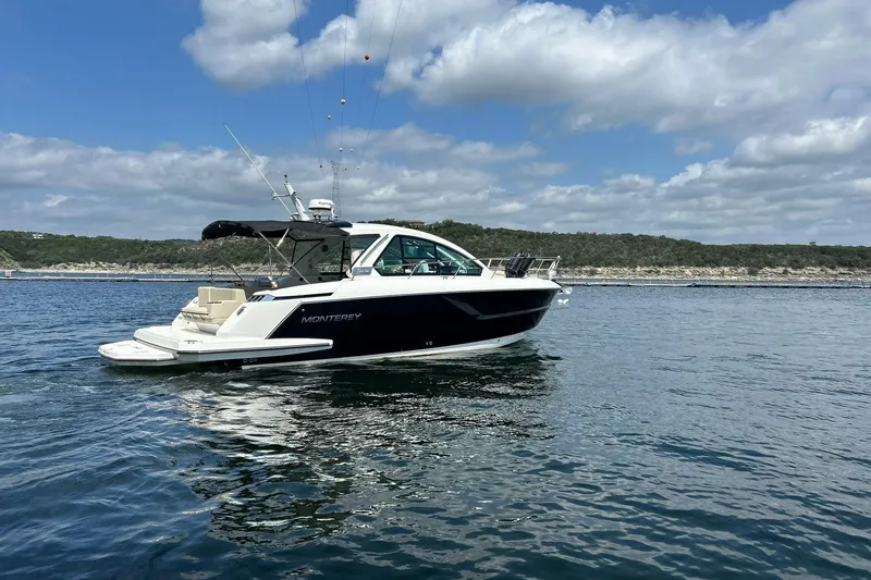 Slide: The Image of 2017 Monterey 360 Sport Coupe cruising on a serene lake under a partly cloudy sky. - 17