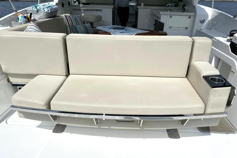 Slide: The Image of Luxurious seating on a 2017 Monterey 360 Sport Coupe yacht, featuring beige cushions and cup holder. - 21