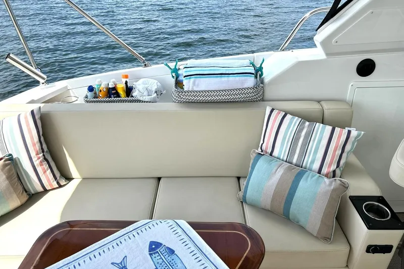 Slide: The Image of Luxurious seating area on a 2017 Monterey 360 Sport Coupe yacht with striped cushions. - 25