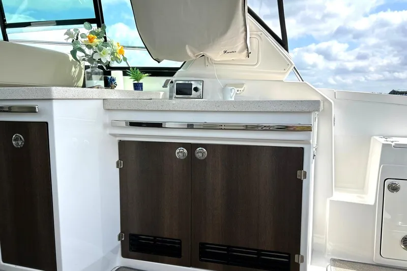 Slide: The Image of 2017 Monterey 360 Sport Coupe yacht interior with sleek cabinetry and countertop, featuring floral decor. - 30