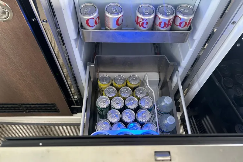 Slide: The Image of Refrigerator stocked with soda cans and water bottles in a 2017 Monterey 360 Sport Coupe. - 38