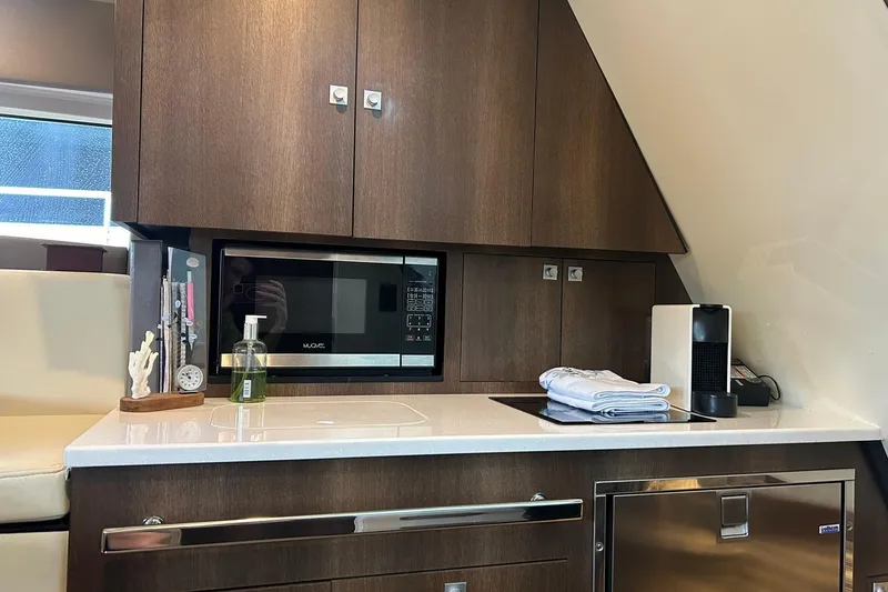 Slide: The Image of Modern kitchenette in 2017 Monterey 360 Sport Coupe with microwave, cabinets, and countertop essentials. - 69