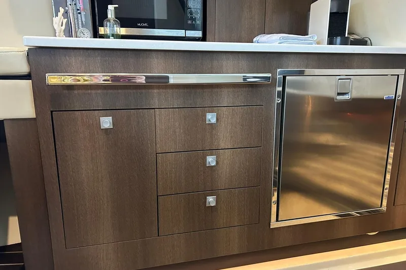 Slide: The Image of Modern kitchen area in a 2017 Monterey 360 Sport Coupe yacht with wood cabinetry. - 70