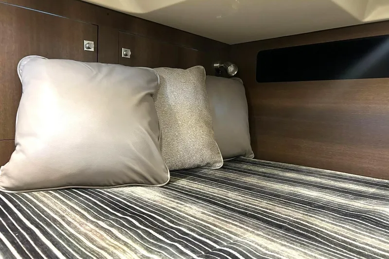 Slide: The Image of Interior cabin of 2017 Monterey 360 Sport Coupe with plush pillows and striped bedding. - 72