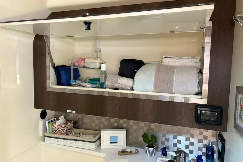 Slide: The Image of Open cabinet in 2017 Monterey 360 Sport Coupe with towels and toiletries. - 75