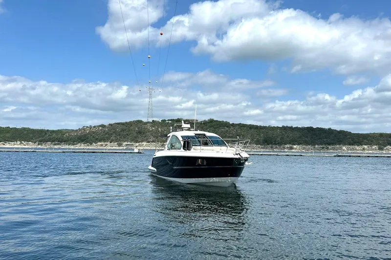 Slide: The Image of 2017 Monterey 360 Sport Coupe cruising on a scenic lake under a partly cloudy sky. - 9