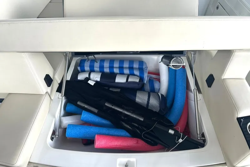 Slide: The Image of Storage compartment of 2017 Monterey 360 Sport Coupe filled with colorful pool noodles and gear. - 91