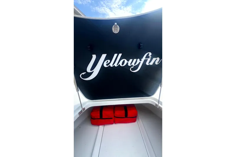 Slide: The Image of 2017 Yellowfin 21 Hybrid boat interior with storage compartment and red bags. - 12