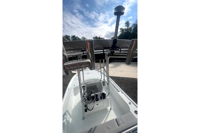 Slide: The Image of 2017 Yellowfin 21 Hybrid boat cockpit with steering wheel and controls under a blue sky. - 19