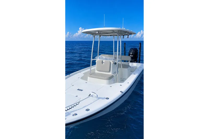 Slide: The Image of 2017 Yellowfin 21 Hybrid boat on trailer, parked on a gravel path near trees. - 24