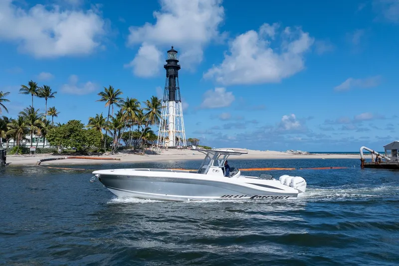 Slide: The Image of 2019 Deep Impact 369 Sport boat cruising near a lighthouse and palm trees under a blue sky. - 100
