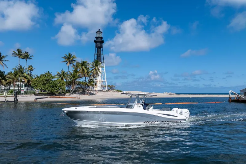 Slide: The Image of 2019 Deep Impact 369 Sport boat cruising near a lighthouse and palm trees under a blue sky. - 101
