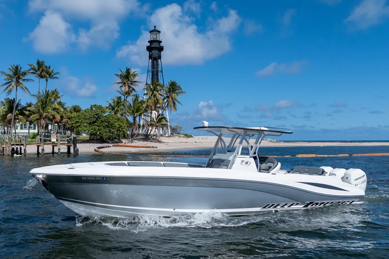 Slide: The Image of 2019 Deep Impact 369 Sport boat cruising near a lighthouse and palm trees. - 103