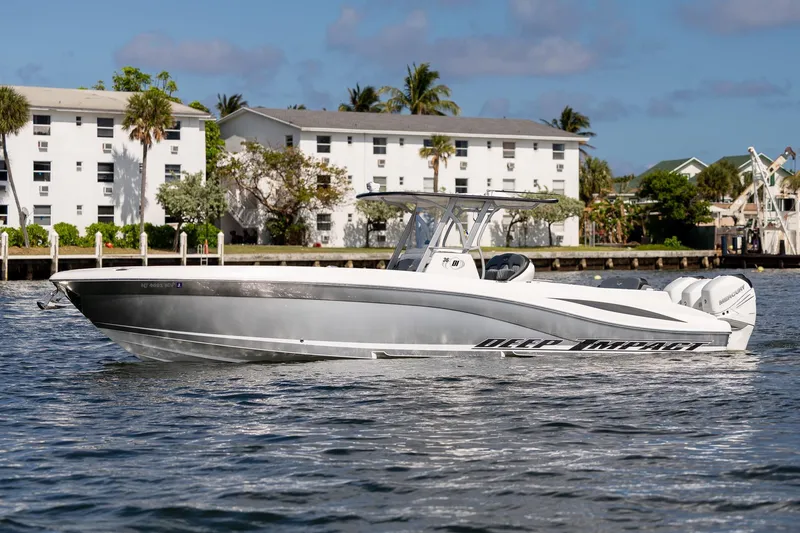 Slide: The Image of 2019 Deep Impact 369 Sport boat on water, with buildings and palm trees in background. - 19