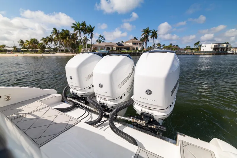 Slide: The Image of 2019 Deep Impact 369 Sport boat with triple Mercury outboard engines on a sunny waterfront. - 56