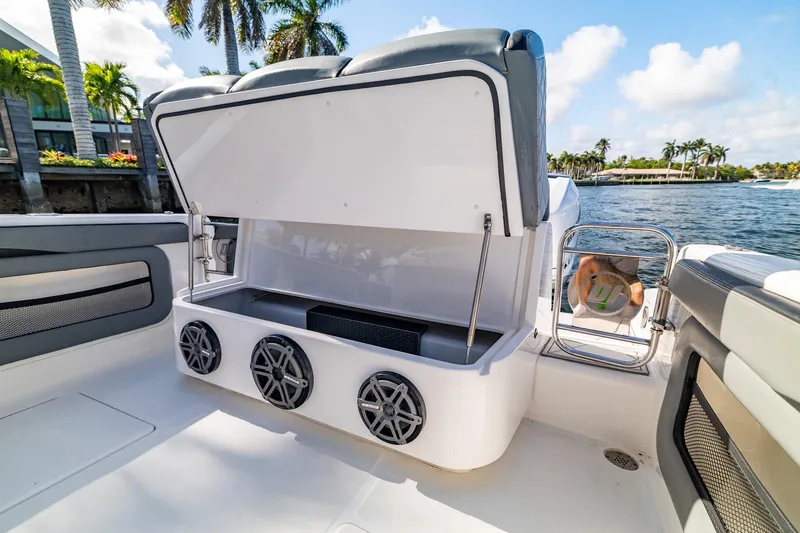 Slide: The Image of 2019 Deep Impact 369 Sport boat interior with open storage and speakers, dockside view. - 72