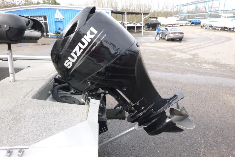 Slide: The Image of 2005 Tracker Tournament V-18 All Fish boat with Suzuki outboard motor in a marina setting. - 13