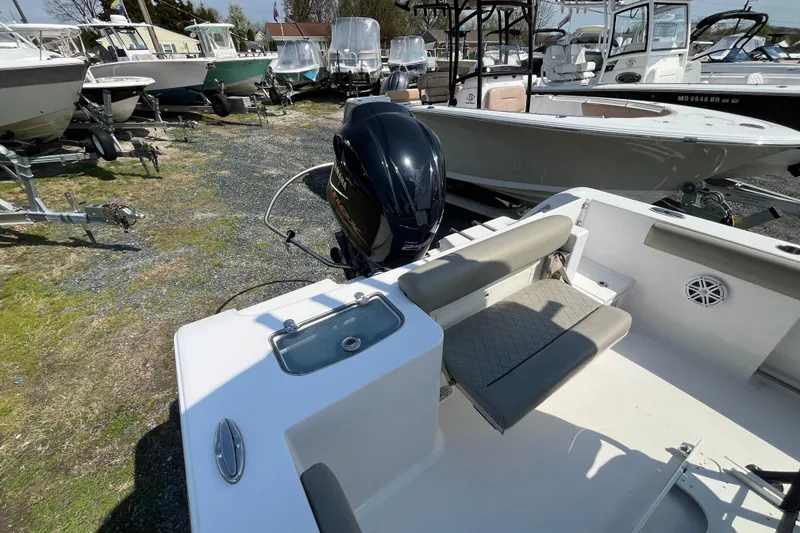 Slide: The Image of 2022 Sportsman Open 242 Center Console boat with seating and motor, displayed outdoors. - 16