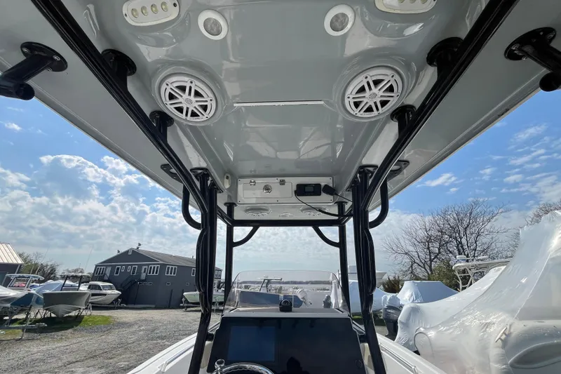Slide: The Image of 2022 Sportsman Open 242 Center Console boat interior with speakers and electronics under a clear sky. - 17
