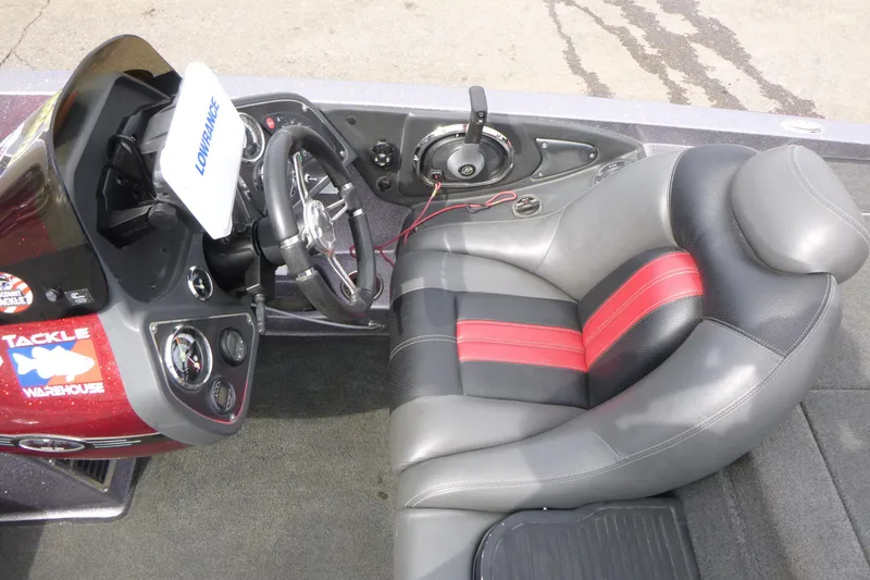 Slide: The Image of 2010 Ranger Z521 boat cockpit with steering wheel, control panel, and cushioned seat. - 11