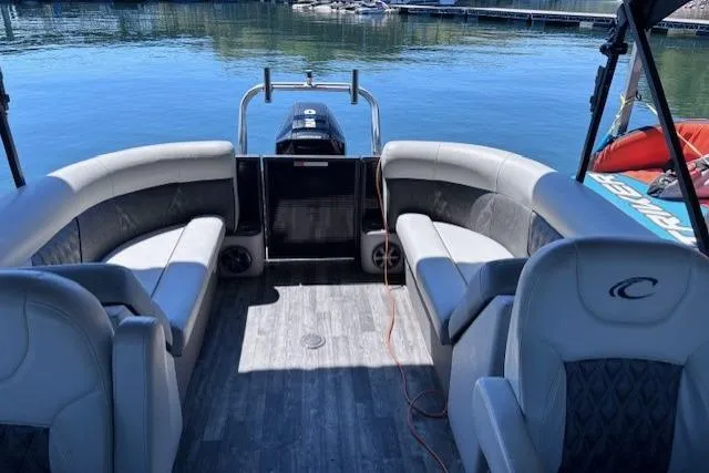 The Image of 2019 Crest 220 CREST III pontoon boat interior with gray seating, docked on calm water. - 1