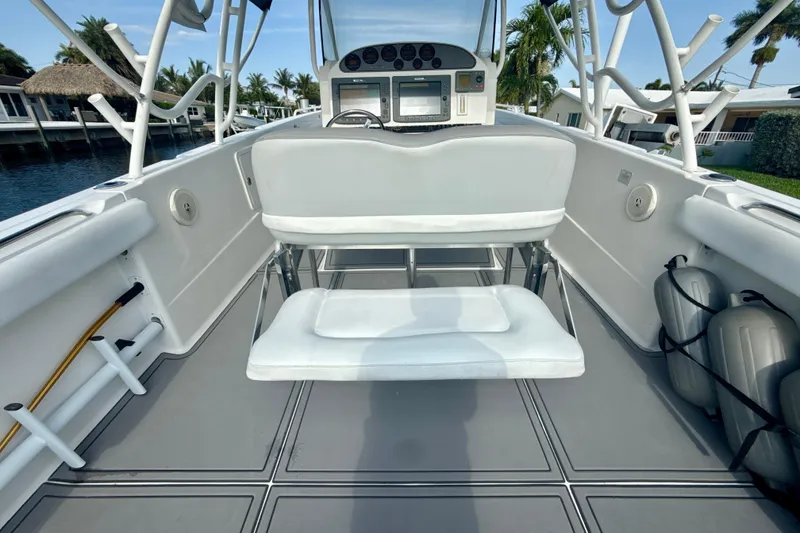 Slide: The Image of 2006 Wellcraft 352 Sport boat interior with seating and control panel, docked near palm trees. - 11