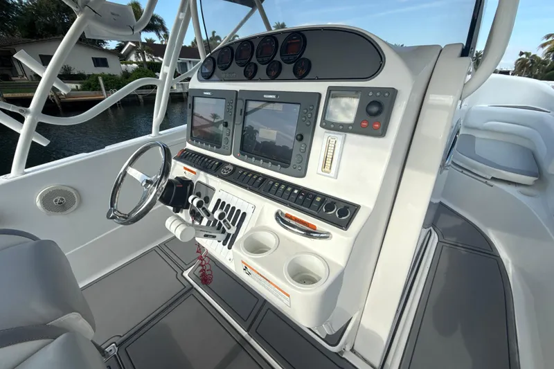 Slide: The Image of 2006 Wellcraft 352 Sport boat dashboard with steering wheel and navigation controls. - 13