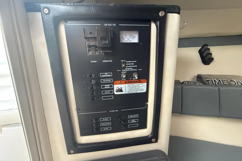 Slide: The Image of Electrical panel inside 2006 Wellcraft 352 Sport boat cabin, featuring various switches and warnings. - 22