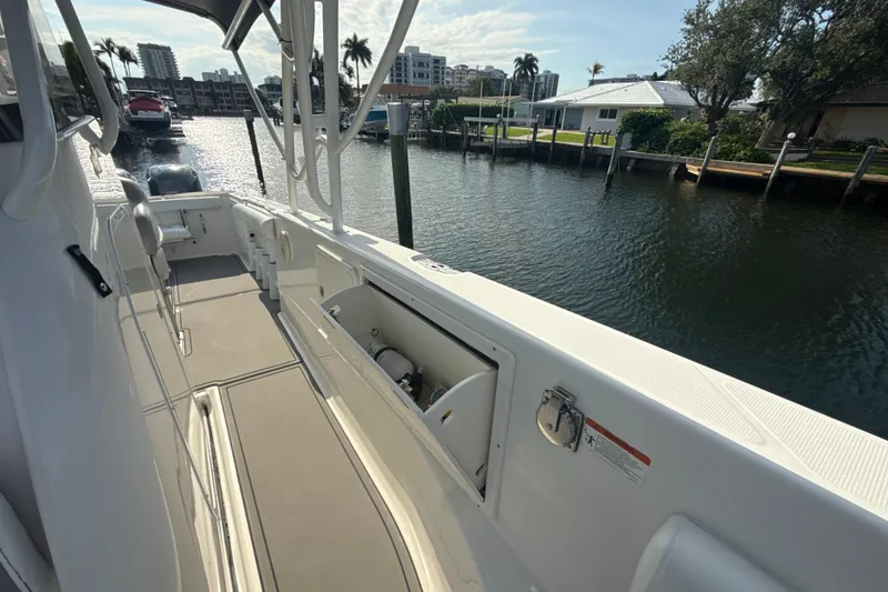 Slide: The Image of 2006 Wellcraft 352 Sport boat docked by waterfront homes, sunny day. - 23