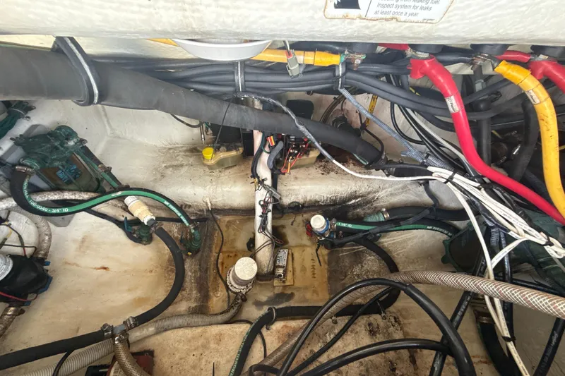 Slide: The Image of Engine compartment of a 2006 Wellcraft 352 Sport boat with visible wiring and hoses. - 27