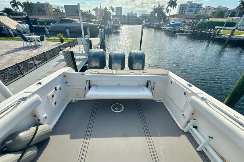 Slide: The Image of 2006 Wellcraft 352 Sport boat docked, featuring spacious deck and dual outboard engines. - 8