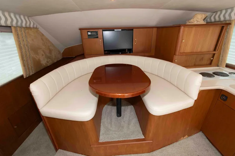 Slide: The Image of Luxurious interior of 2001 Ocean Yachts 40 Super Sport with curved seating and wooden table. - 14