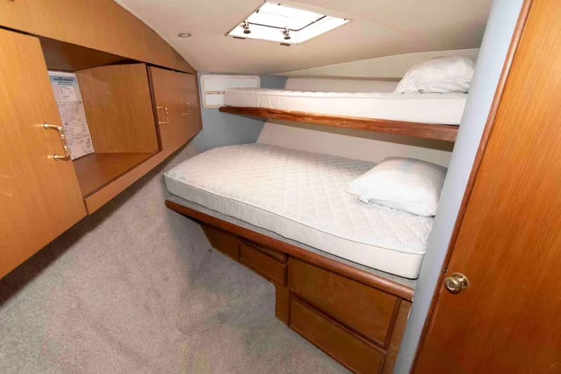 Slide: The Image of 2001 Ocean Yachts 40 Super Sport cabin with bunk beds and wooden storage. - 17