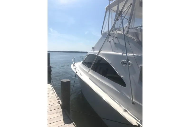 Slide: The Image of 2001 Ocean Yachts 40 Super Sport boat on land, surrounded by equipment and trees. - 2