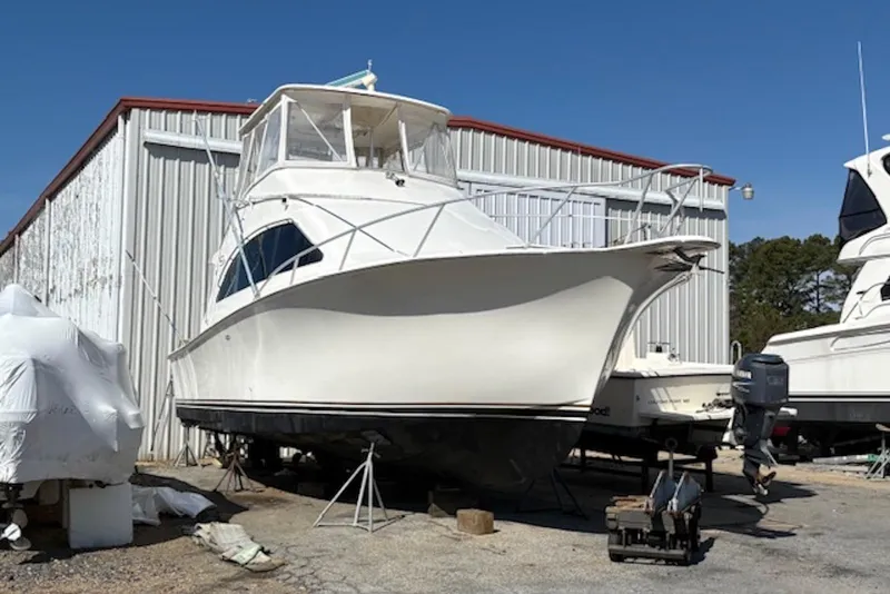Slide: The Image of 2001 Ocean Yachts 40 Super Sport boat docked, featuring spacious deck and fishing rod holders. - 4