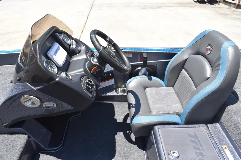 Slide: The Image of 2026 Triton 179 TrX boat cockpit with steering wheel and cushioned seat. - 25