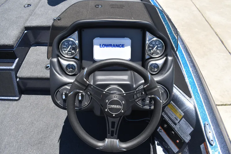Slide: The Image of 2026 Triton 179 TrX boat dashboard with steering wheel and Lowrance display. - 26