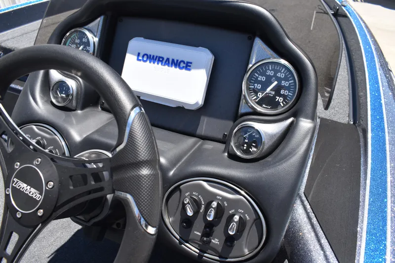 Slide: The Image of Dashboard of a 2026 Triton 179 TrX boat featuring steering wheel and gauges. - 27