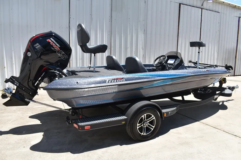 Slide: The Image of 2026 Triton 179 TrX bass boat with powerful outboard motor, parked on trailer. - 4