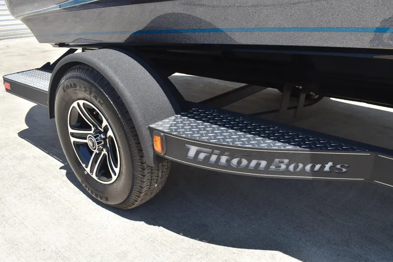 Slide: The Image of Trailer of 2026 Triton 179 TrX boat with Load Star tire and Triton Boats branding. - 49