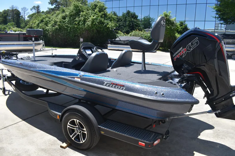 Slide: The Image of 2026 Triton 179 TrX bass boat with Mercury Pro XS engine, parked outdoors. - 6