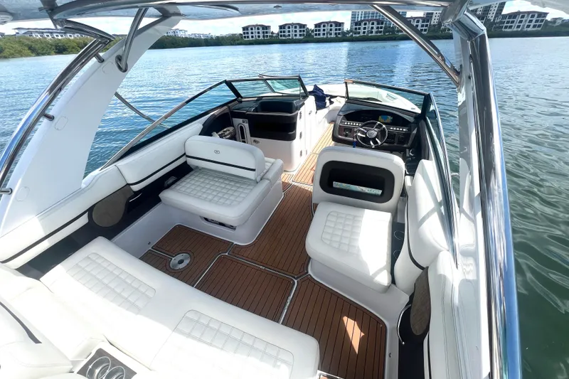 Slide: The Image of 2017 Cobalt R30 boat interior with white seating and wooden flooring on a calm lake. - 16