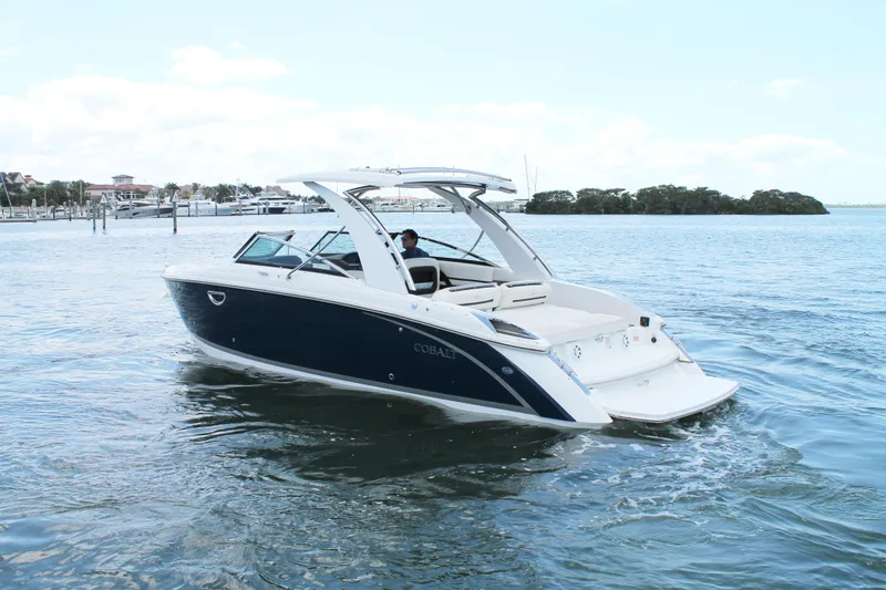 Slide: The Image of 2017 Cobalt R30 boat cruising on calm waters near a marina. - 5