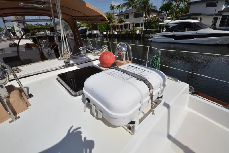 Slide: The Image of Hinckley Sou'wester 59 yacht deck with safety equipment, docked by waterfront homes. - 12