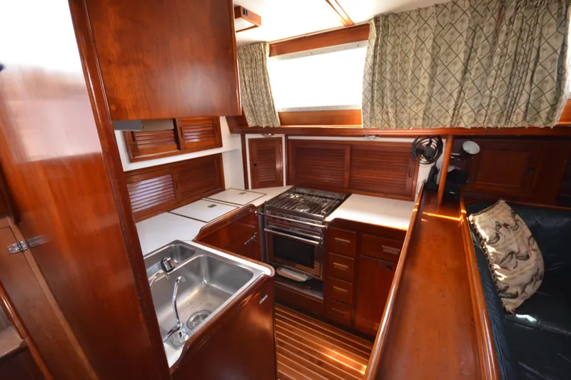 Slide: The Image of Interior of 1992 Hinckley Sou'wester 59 yacht, featuring a wooden galley with stove and sink. - 24