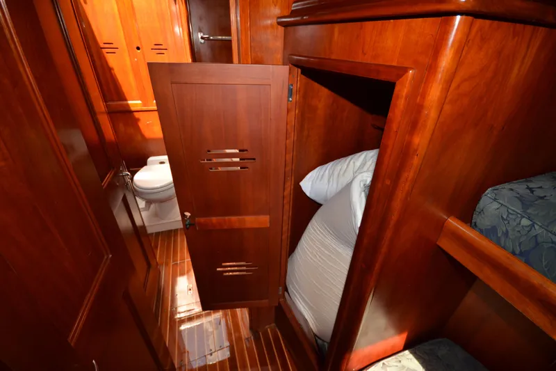 Slide: The Image of Interior of 1992 Hinckley Sou'wester 59 yacht, featuring wooden cabinetry and a compact bathroom. - 38