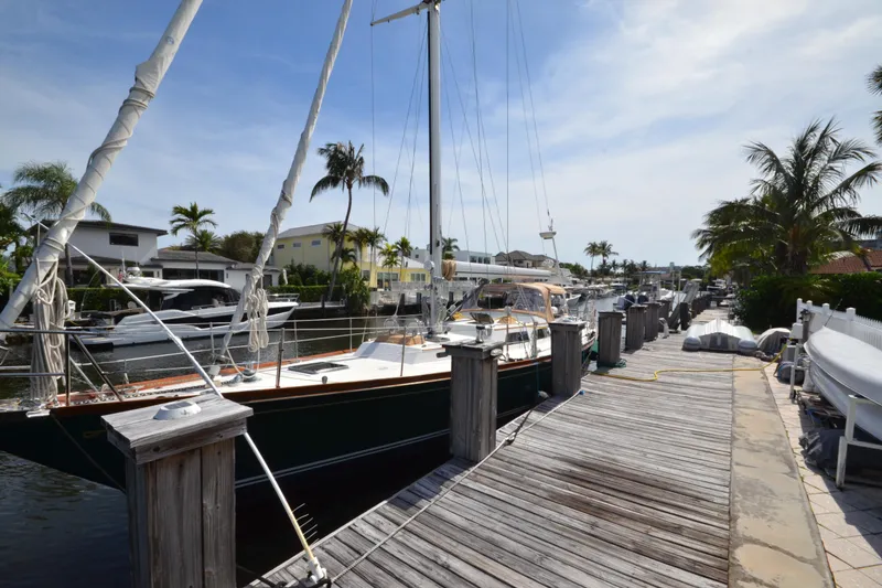 Slide: The Image of Hinckley Sou'wester 59 yacht docked at a sunny marina, surrounded by palm trees. - 4