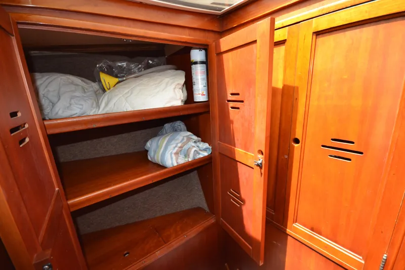 Slide: The Image of Wooden storage cabinet inside 1992 Hinckley Sou'wester 59 yacht, featuring shelves with bedding. - 43
